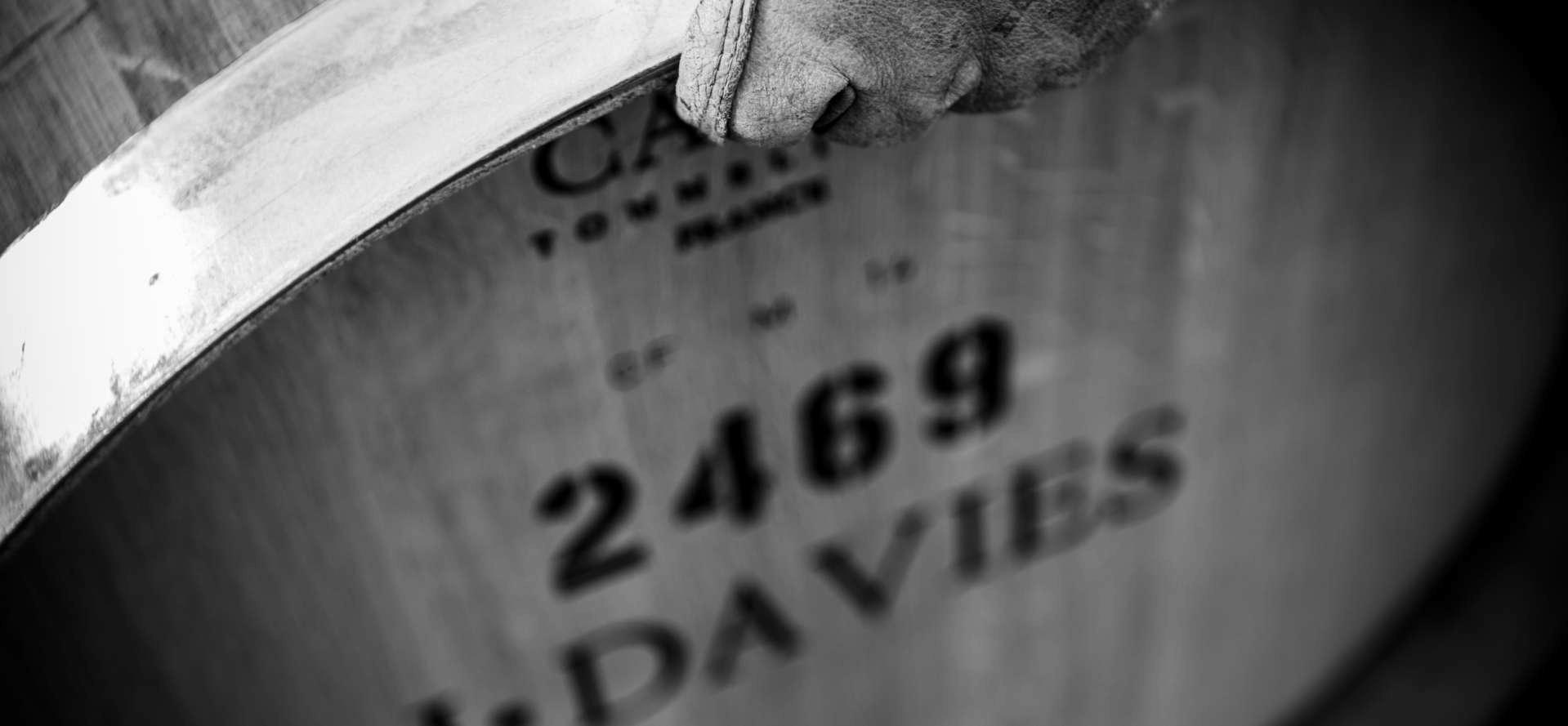 Winery worked hands lift oak barrels at Davies Vineyards